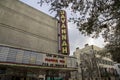 The Historic Savannah Theatre with a tall red neon sign with lush green trees, tall black light posts and blue sky in Savannah Royalty Free Stock Photo