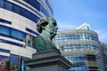 Historic bronze sculpture of Friedrich Wilhelm von Schadow, a German painter, unveiled in 1869, in front of modern buildings.