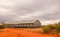 An historic sheep shearing shed with red dirt and overcast sky background Royalty Free Stock Photo