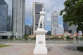 White marble statue of Sir Stamford Raffles, founder of modern Singapore, with financial district in background