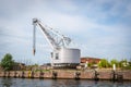Historic slewing crane stands at the quay of an old transshipment port