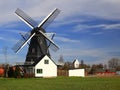 Historic smock mill with church in background in Kyrkokopinge, near Trelleborg, Sweden