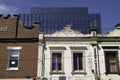 Historic somewhat weathered old decorated colonial facades with new glass building