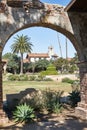 Historic Spanish Style Mission Church building in California framed in an arch during the day Royalty Free Stock Photo