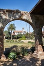 Historic Spanish Style Mission Church building in California framed in an arch during the day Royalty Free Stock Photo