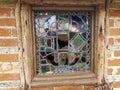 A vintage stained glass window set in a brick wall. Royalty Free Stock Photo