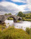 Historic steep stone arch bridge crossing a river - Pont Fawr (Inigo Jones Bridge) North Wales Royalty Free Stock Photo