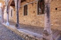 Historic stone building with arched walkway and cobblestone path in sunlight Royalty Free Stock Photo