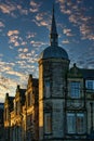 Historic stone building with a spire against a dramatic sky with golden sunset clouds in Lancaster