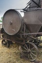 Historic straw press following a threshing machine in operation. The wheel turns and shows motion blur