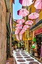 Historic tenement houses and narrow streets decorated with pink umbrellas of old town in perfumery city of Grasse in France