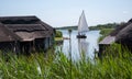 Historic thatched boathouses nestling amongst the verdant reeds at Hickling Broad in Stalham, east of Norwich, in Norfolk UK.