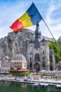 The historic town of Dinant with the Belgian flag and the citadelle on the rock and Collegiate Church of Notre-Dame at the Meuse Royalty Free Stock Photo