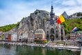 The historic town of Dinant with the Belgian flag and the citadelle on the rock and Collegiate Church of Notre-Dame at the Meuse Royalty Free Stock Photo