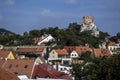 A historic town with red roofs under a hill with a round stone tower Royalty Free Stock Photo