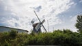 Historic windmill behind tress with clouds and backlight Royalty Free Stock Photo