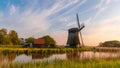 Historic windmill in Netherlands countryside with dramatic sky.