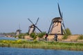 Historic windmills with cyclists cycling in foreground, at Kinderdijk, Holland, Netherlands, a UNESCO World Heritage Site.