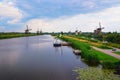 Historic windmills and a river with a boat in Kinderdijk, Netherlands