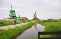 Historic windmills & tourists cycling in Zaanse Schans, Netherlands Royalty Free Stock Photo