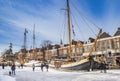 Historic wooden sailing ships in the frozen canal of Dokkum