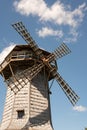 Historic wooden windmill against blue sky with clouds Royalty Free Stock Photo