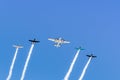 Historical airplanes flying in formation, leaving behind a white smoke trail; California