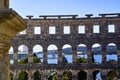 The historical amphitheater of Pula, Croatia in front of the Adriatic Sea with a marina