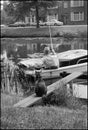 Historical black and white image of a fishing man and a waiting cat