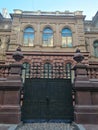 Historical building with ornaments and fence with wrought iron gates