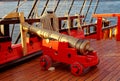 Historical cannon of an old wooden sailboat. Details deck of the ship.