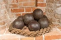 Historical cannonballs arranged in a decorative display on a rope base in a rustic brick setting Royalty Free Stock Photo