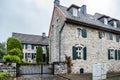 Historical mansion house with black iron gate and green window shutters