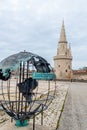 Modern sculpture and medieval lighthouse at La Rochelle, France