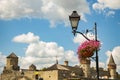 Historical old city street lantern lamppost and blossom flower vase with medieval castle landmark tower architecture shape Royalty Free Stock Photo