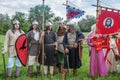 Historical reenactors in suits and with weapons in the ranks