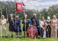 Historical reenactors in suits and with weapons in the ranks