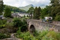 The historical stone bridge of the A827 road above the river and falls of  Dochart in Killin, Scotland. Green Land Rover Defender Royalty Free Stock Photo