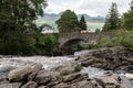 The historical stone bridge of the A827 road above the river and falls of  Dochart in Killin, Scotland with a red car with motion Royalty Free Stock Photo