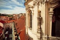 Historical tower of Baroque church building with sculptures and red tiled roof
