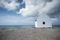 Historical white slave house on a beach under a cloudy sky in Bonaire