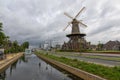 Historical wind mill by a canal in Delft , the Netherlands