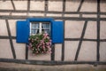 Historical windows with geraniums in alsatian village Royalty Free Stock Photo