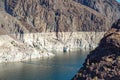 A historically low water level of Hoover Dam and Lake Mead. Dark rocks blanched by white calcium ring where the water level once Royalty Free Stock Photo