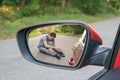 Hit and run concept. View on injured man on road in rear mirror of a car Royalty Free Stock Photo