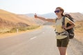 Hitchhiker traveler woman on the road in sunset. Girl traveler hiker on the road. Summer vacation. Freedom. Royalty Free Stock Photo