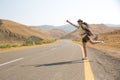 Hitchhiker traveler woman on the road in sunset. Girl traveler hiker on the road. Summer vacation. Freedom. Royalty Free Stock Photo