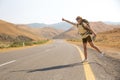 Hitchhiker traveler woman on the road in sunset. Girl traveler hiker on the road. Summer vacation. Freedom. Royalty Free Stock Photo