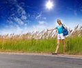 Hitchhiking girl votes on road.Portrait in a sunny day