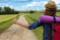 Hitchhiking road travel. Woman with a big backpack trying to stop a ride